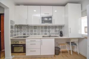 eine weiße Küche mit weißen Schränken und einem Waschbecken in der Unterkunft Laranjal 7 in Lissabon