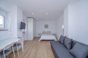ein Wohnzimmer mit einem Sofa und einem Bett in der Unterkunft Laranjal 7 in Lissabon