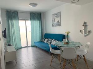 a living room with a blue couch and a table at La Perla de Sunset Beach in Corralejo