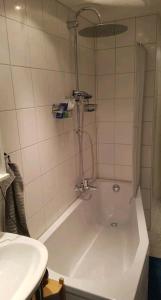 a bath tub with a shower in a bathroom at Apartment im Zentrum in Frankfurt