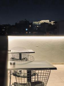 アテネにあるNavitas Houseのテーブル2台、水辺の景色を望むバルコニーと椅子