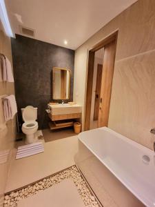 庫塔的住宿－Truntum Boutique Mandalika，带浴缸、卫生间和盥洗盆的浴室