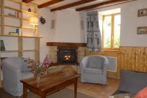 uma sala de estar com duas cadeiras e uma lareira em Gîte des Bruns en chartreuse em Entremont-le-Vieux