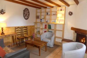 uma sala de estar com uma mesa e cadeiras e uma lareira em Gîte des Bruns en chartreuse em Entremont-le-Vieux