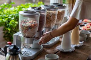 a woman is preparing food in four blenders at Hotel Cocoliso Island Resort in Isla Grande