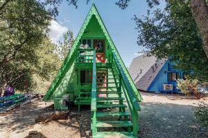 a house shaped like a pyramid with a green staircase at Hicksville Pines Chalets & Motel in Idyllwild