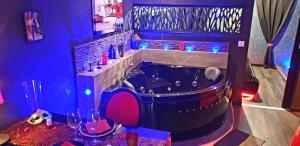 a bath tub in a room with blue lights at PLAISIR EXTREME in Roanne