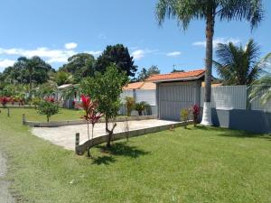 a house with a yard with grass and trees at Pousada do Alemão - Cananéia in Cananéia