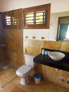 a bathroom with a toilet and a sink at Casa do Capitao in Guajiru