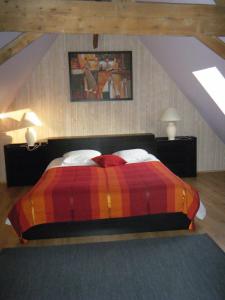 Gîte Du Haut Ballot في Wambrechies: غرفة نوم مع سرير وبطانية ملونة
