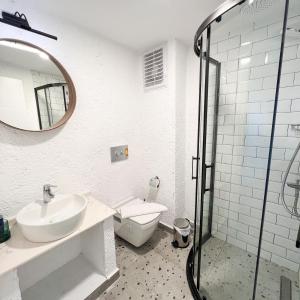 La salle de bains est pourvue d'un lavabo, de toilettes et d'un miroir. dans l'établissement Aloha Suites, à Marmaris