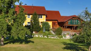 una gran casa amarilla con patio en Ferienwohnungen Hanetseder, en Wallern an der Trattnach