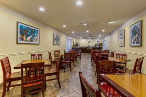 uma sala de jantar com mesas e cadeiras de madeira em Best Western Phoenix Goodyear Inn em Goodyear