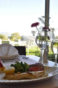 a table with a plate of food and a glass of wine at Orty Airport Hotel in Izmir +31 photos