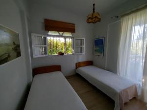 a bedroom with two beds and a window at O&A By the Sea in Polykhrono