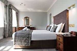 a bedroom with a large bed with a wooden headboard at The Lansdowne, Eastbourne in Eastbourne