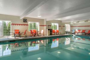 a swimming pool with red chairs and red tables at Best Western Plus Park Place Inn & Suites in Chehalis