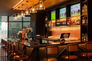 a bar in a restaurant with chairs and a counter at Radisson Blu Hotel, Dubai Media City in Dubai