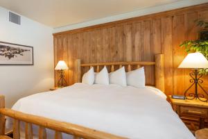 a bedroom with a large white bed with wood paneling at 1 Bedroom Condo - The Lodges at Deer Valley condo in Park City +19 photos