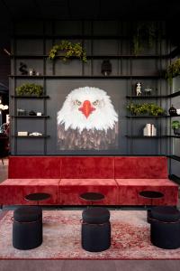 a red couch in a room with a picture of an owl at Radisson RED Oslo Økern in Oslo