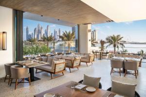 a restaurant with tables and chairs and a view of the city at Radisson Beach Resort Palm Jumeirah in Dubai