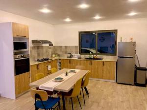 a kitchen with a table and chairs and a refrigerator at Sunny Side Up in Grand Baie