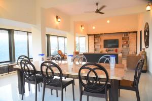 a dining room with a large wooden table and chairs at Rozaan Villa Valley View in Mahabaleshwar