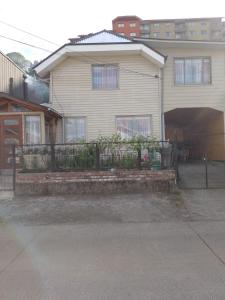 a house with a fence in front of it at Flor/Victoria in Villarrica