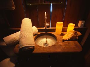 a bathroom sink with two paper towels and candles at Chalés da VoVó in Atins