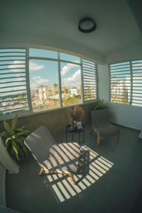 a living room with a couch and a chair and windows at SOKZO Miramar in San Juan