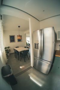 Il comprend une cuisine équipée d'un réfrigérateur en acier inoxydable et d'une table. dans l'établissement SOKZO Miramar, à San Juan