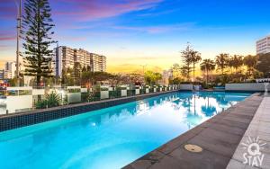 a swimming pool on the roof of a building at Avalon Apartments - QStay in Gold Coast