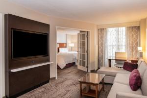 a hotel room with a television and a bed at Chicago Marriott Suites Deerfield in Deerfield