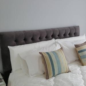 un montón de almohadas sentadas en una cama en Departamento Caseros Desing en Salta