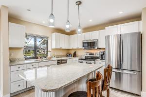 a kitchen with white cabinets and a large kitchen island at Menorca Court in Marco Island