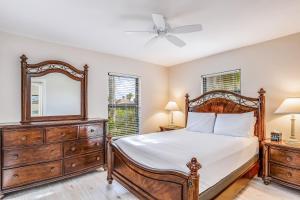 a bedroom with a bed and a mirror and a dresser at Menorca Court in Marco Island +29 photos