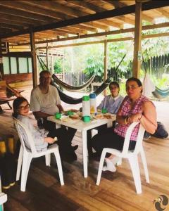 Un groupe de personnes assises autour d'une table blanche dans l'établissement Hotel Lomas del Paiyü, à Puerto Nariño