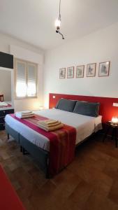 1 dormitorio con 1 cama grande y cabecero rojo en La Casa delle Storie, en Teramo