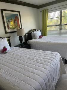 um quarto de hotel com duas camas e uma janela em Colony Club Inn & Suites em Nassau