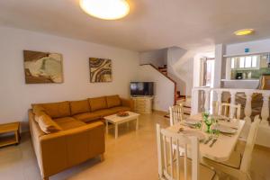 a living room with a couch and a table at Rentaliday Garden Beach in Playa de las Americas