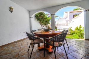 a wooden table and chairs on a patio at Rentaliday Garden Beach in Playa de las Americas