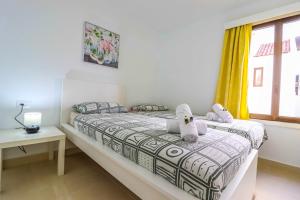 a bedroom with a bed and a window at Rentaliday Garden Beach in Playa de las Americas +29 photos