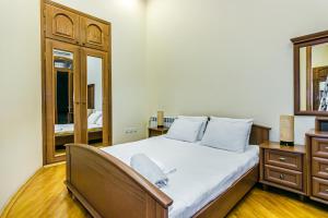 1 dormitorio con 1 cama grande y espejo en Amazing Apartment İn Center en Baku