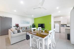 uma cozinha e sala de estar com uma mesa e um sofá em Your Keys to Larrakeyah Coastal Comfort with Pool em Larrakeyah
