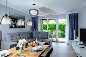 a living room with a couch and a table at Apartament POŁUDNIOWY nad morzem Gardenia Międzywodzie EPapartamenty in Międzywodzie