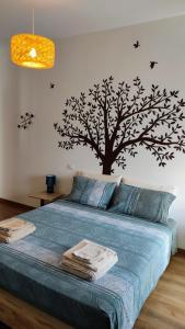 un dormitorio con un árbol con pájaros en la pared en La Casa delle Storie, en Teramo