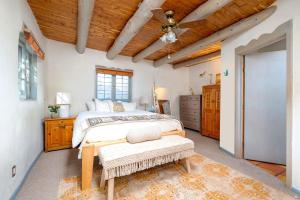 a bedroom with a bed and a wooden ceiling at Besos on Canyon Road in Santa Fe