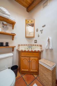 a bathroom with a toilet and a sink and a mirror at Besos on Canyon Road in Santa Fe