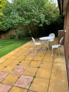 a patio with two chairs and a table and a table and chairs at Spacious Furnished Bungalow with Garden n Parking in Bradenham