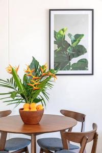 a table with a bowl of oranges and a plant at 'Botanica Bonita' A Stylish Nightcliff Hideaway in Nightcliff